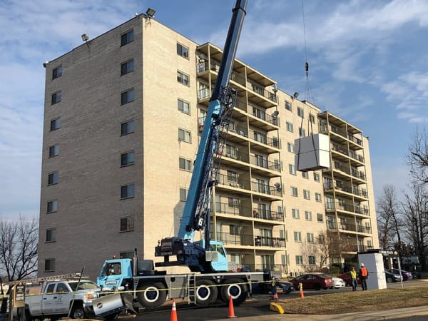large apartment building complex, eight stories tall, roof replacement in progress